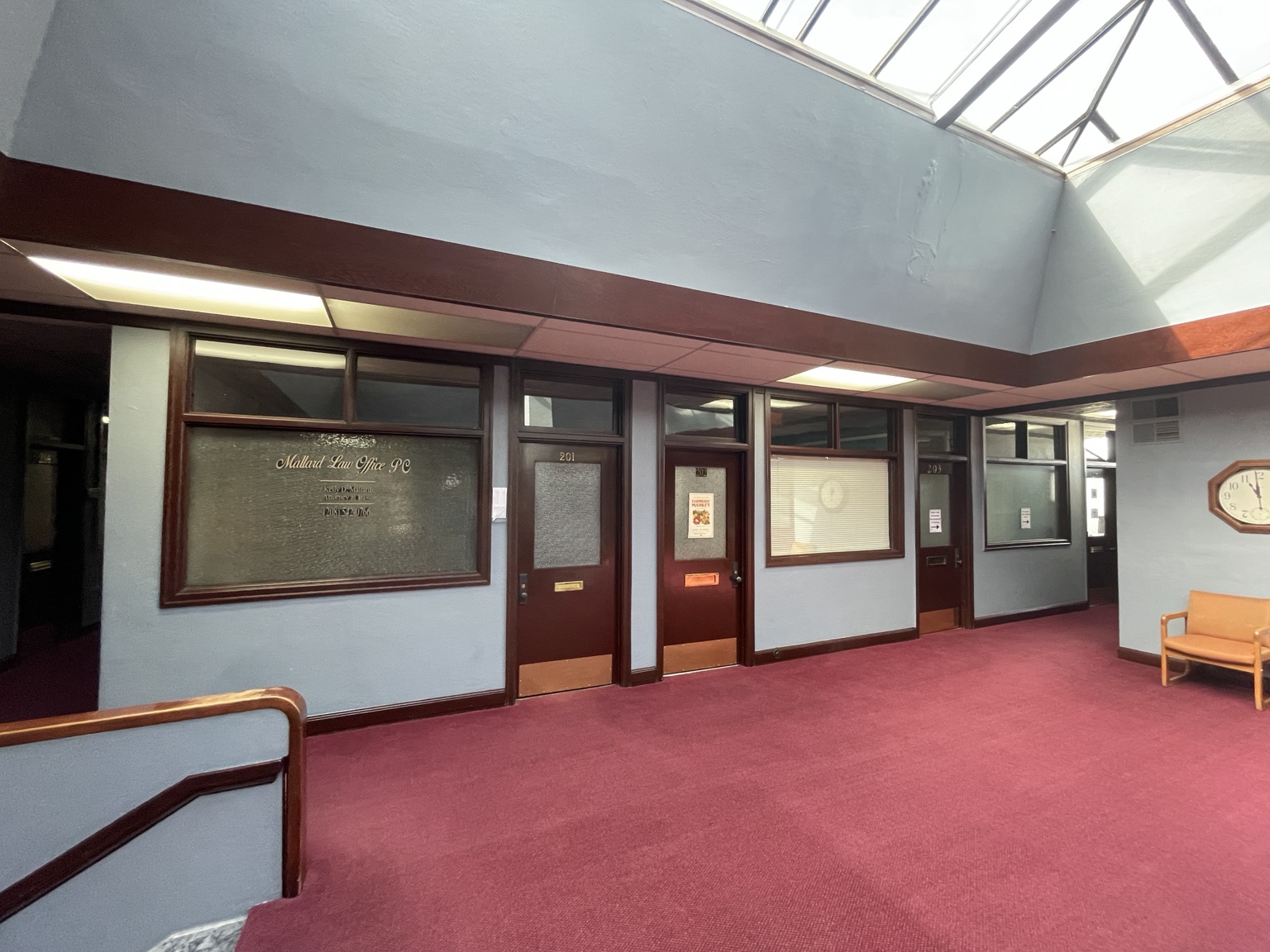 Professional office doors near skylit hallway